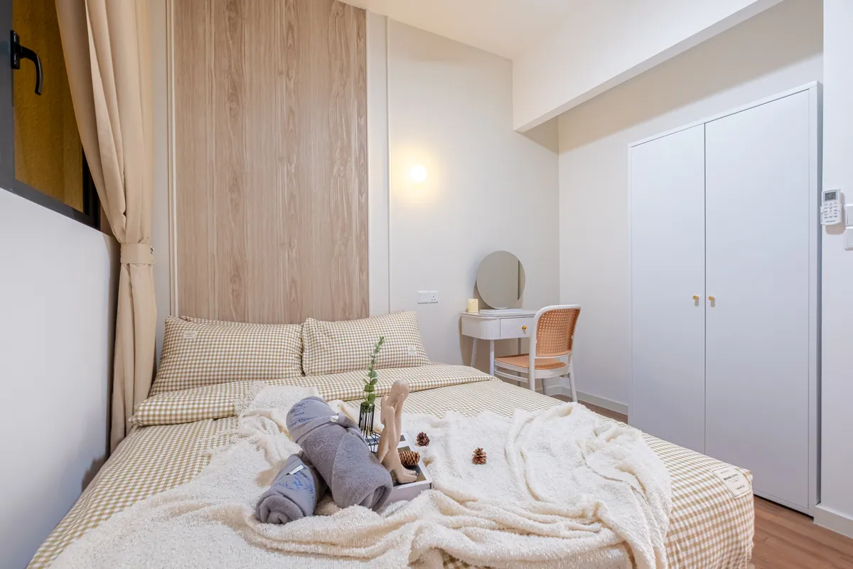 Fresh linens and rolled towels on a queen bed