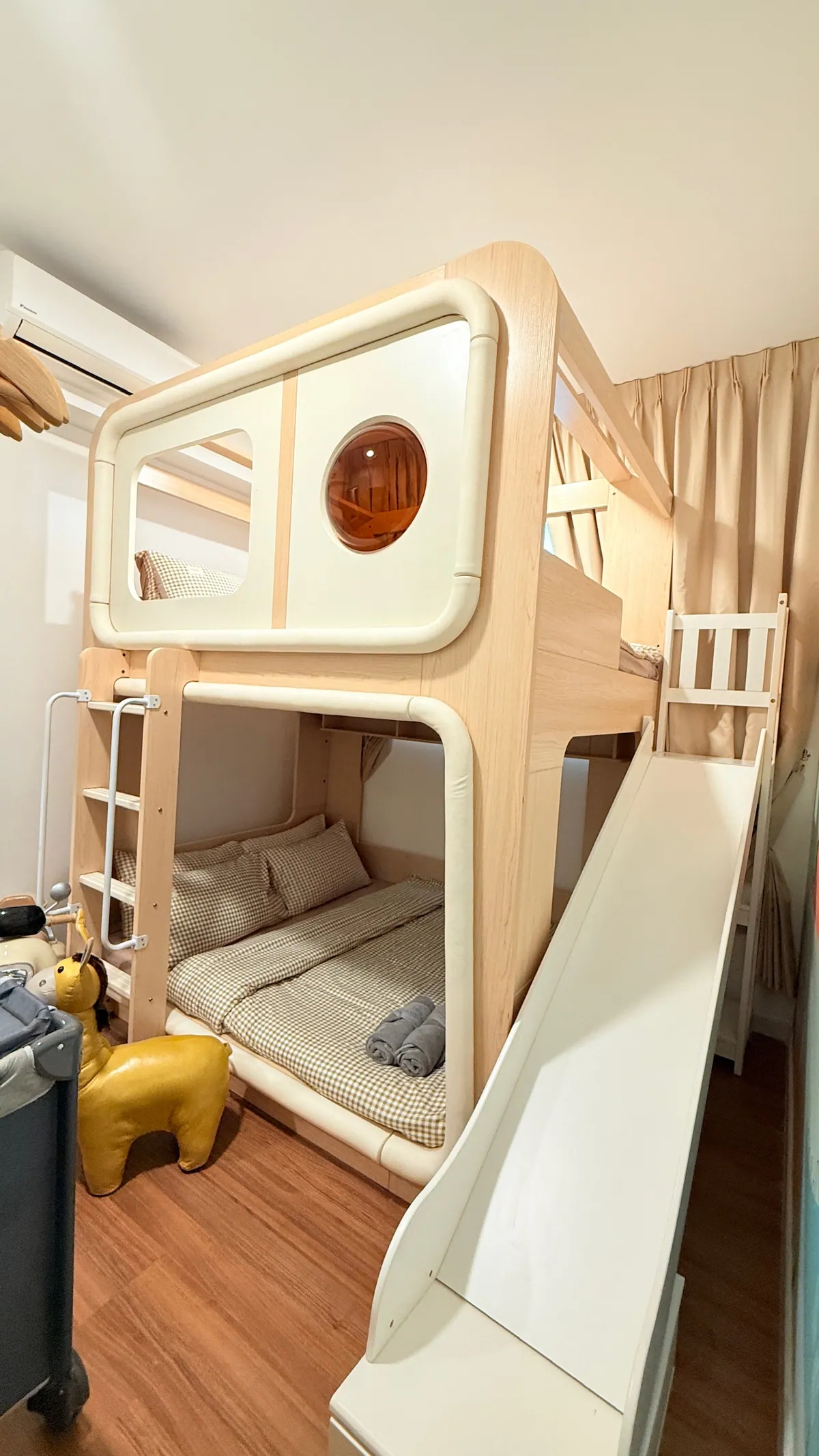 The kids' room bunk house with its full-length white slide and a ride-on giraffe